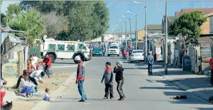  ??  ?? HOT SPOT: Police in a Nyala and another patrol vehicle keep watch on Renoster Street in Manenberg, one of four areas identified by police as battlegrou­nds for Hard Livings and Americans gangsters fighting for turf. Pictures: LEON LESTRADE