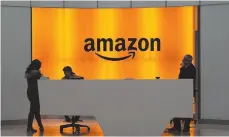  ?? AP FILE PHOTO ?? People stand in the lobby for Amazon offices in New York in this undated photo.