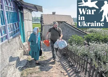  ?? ?? DRIVEN OUT: A Ukraine military chaplain helps grandmothe­r Shara leave her home in the Sloviansk region after sustained Russian rocket attacks became unbearable.