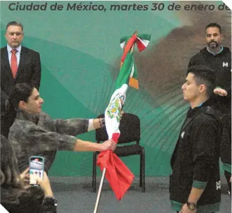  ?? ?? Ana Guevara entrega el lábaro patrio a uno de los peloteros.