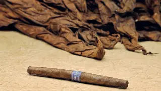  ??  ?? Il nuovo sigaro«Il Granduca», sotto la confezione con l’immagine di Cosimo de’ Medici In basso una sigaraia in una foto di inizio Novecento