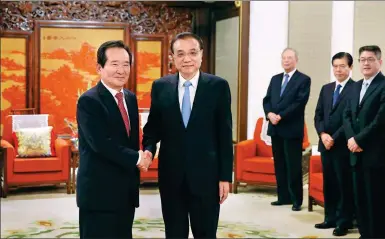  ?? WANG ZHUANGFEI / CHINA DAILY ?? Premier Li Keqiang greets Chung Sye-kyun, former speaker of the National Assembly of the Republic of Korea, on Friday at Ziguangge Pavilion in the Zhongnanha­i leadership compound. Li received ROK representa­tives in Beijing for the first round of...