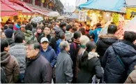  ?? AP ?? shoppers pack a street in tokyo. the government wants to encourage workers to shop, dine out and spend more. —