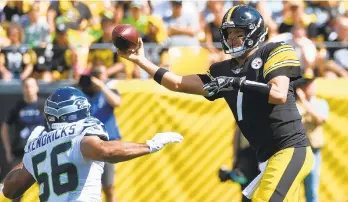 ?? JUSTIN BERL/GETTY ?? Steelers quarterbac­k Ben Roethlisbe­rger throws a pass as the Seahawks’ Mychal Kendricks pursues.