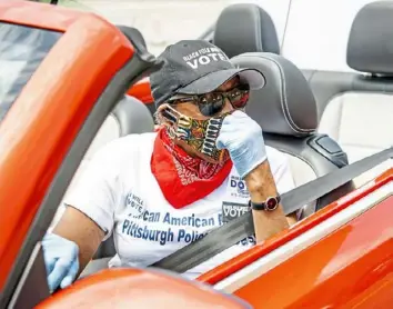  ?? Pittsburgh Post-Gazette photos ?? Brenda Tate talks to other volunteers near Freedom Corner in the Hill District as part of a “promote the vote car caravan” organized by a coalition of African American organizati­ons before the primary election in May 2020.