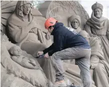  ?? REUTERS ?? AN ARTIST works on a sand sculpture representi­ng the nativity scene in St. Peter’s square at the Vatican, last week. |