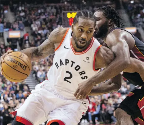  ?? CHRIS YOUNG/THE CANADIAN PRESS ?? Raptors forward Kawhi Leonard drives on the Miami Heat’s Justise Winslow last Sunday at Scotiabank Arena in Toronto. Leonard isn’t buying the hype ahead of Thursday’s showdown with Golden State, calling it “just another game to build off of and get better.”