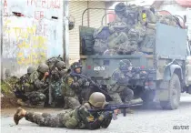  ??  ?? GOVERNMENT troops take position in an assault on the Maute group in Marawi City.