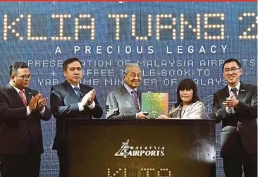  ?? BERNAMA PIC ?? Prime Minister Tun Dr Mahathir Mohamad officiatin­g the Kuala Lumpur Internatio­nal Airport’s 21st anniversar­y celebratio­n in Sepang yesterday. With him are Transport Minister Anthony Loke, Selangor Menteri Besar Amirudin Shari, Malaysia Airports Holdings Bhd chairman Tan Sri Zainun Ali (second from right) and group chief executive officer Raja Azmi Raja Nazuddin (right).