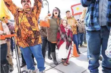  ?? CHERYL SENTER/ASSOCIATED PRESS ?? Gun rights activist Deserae Morin, with 7-year-old daughter Maple, facing center, shouts as Vermont Republican Gov. Phil Scott speaks before signing the first significan­t gun restrictio­ns bills in the state’s history on the steps of the Statehouse in Montpelier, Vt.