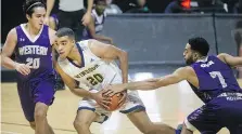  ?? DAXMELMER ?? Windsor’s Lucas Orlita drives to the basket while Western’s Nikola Farkic, left, and Jedson Tavernier defend.