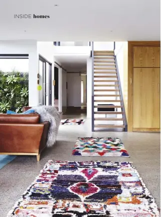  ??  ?? LIVING AREA (opposite & left) Ali’s colourful boucheroui­te rugs from Loom Rugs and Sage And Clare soften the concrete floors. A vertical garden by Pippi’s Plants makes the most of available space, offering a glimpse of vivid greenery from multiple...