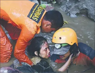  ?? Arimacs Wilander EPA/Shuttersto­ck ?? RESCUERS TRY to free 15-year-old Nurul Istikhomah from the flooded ruins of a house in Palu on Sulawesi island in Indonesia. The teen had been trapped in the water since the quake and tsunami two days earlier.