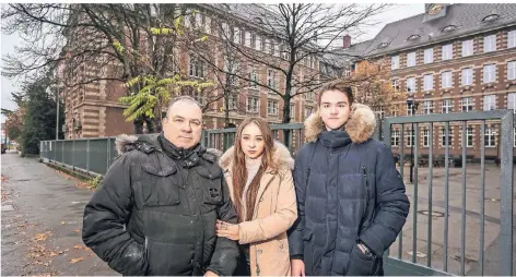  ?? RP-FOTO: HANS-JÜRGEN BAUER ?? Steffen Blumenthal mit seinen Kindern Iana und Ian vor dem Goethe-Gymnasium. Der Vater will nun klagen.