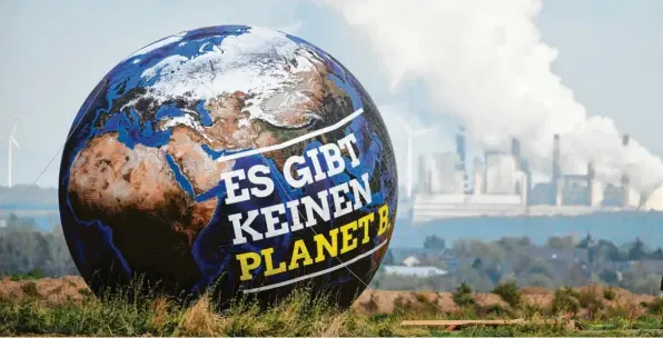  ?? Foto: Ina Fassbender, dpa ?? Ein Ballon mit der Aufschrift „Es gibt keinen Planet B.“ist vor Braunkohle­kraftwerke­n in Nordrhein-Westfalen zu sehen. Der Weltklimar­at drängt zu raschem Handeln für den Klimaschut­z.