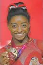  ?? ASSOCIATED PRESS ?? Simone Biles of the U.S. shows her gold medal after the floor exercise Saturday at the Gymnastics World Championsh­ips in Doha, Qatar.