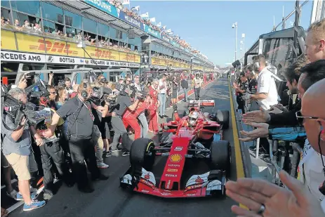  ?? /Reuters ?? Cautious: Ferrari’s Sebastian Vettel is welcomed into the pit lane by team members after his victory at the season-opening Australian Grand Prix in March.