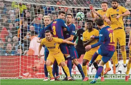  ?? AFP PIC ?? Barcelona’s Lionel Messi curls the ball and scores during the La Liga match against Atletico Madrid on Sunday.