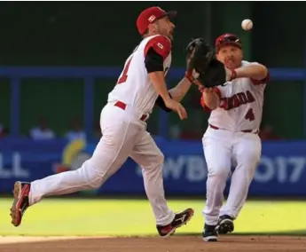  ?? MIKE EHRMANN/GETTY IMAGES ?? Canadian infielders Jonathan Malo and Pete Orr converge on a high hopper in the second inning Saturday.