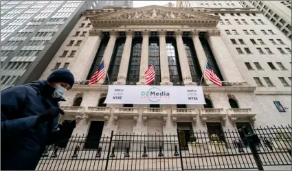  ?? AP Photo/John Minchillo ?? Pedestrian­s pass the New York Stock Exchange, on Jan. 27 in New York.