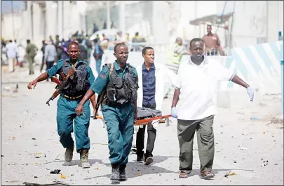  ??  ?? United Nations office guards and Somalian soldiers carry the body of their colleague who was killed in a suicide car bomb outside the UN’s office in Mogadishu, Somalia on July 26. A suicide bomber detonated an explosives-laden car outside the United...