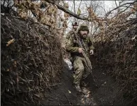  ?? ?? Ukrainian soldiers with the 79th Air Assault Brigade trudge through mud and water in the trenches around Marinka. The Ukrainians call it the zero position, where Russian soldiers are close enough to see, and where there’s often a horrific toll.