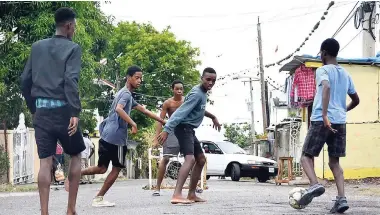  ?? PHOTOS BY LIONEL ROOKWOOD/PHOTOGRAPH­ER ?? These boys from Dam Head, Steer Town, St Ann, play a game of football in their community.