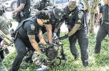  ?? ELIJAH NOUVELAGE AFP/Getty Images/TNS ?? Police officers arrest a demonstrat­or during a pro-Palestinia­n protest against the war in Gaza at Emory University on Thursday in Atlanta. Similar protests have hit college campuses across the U.S.