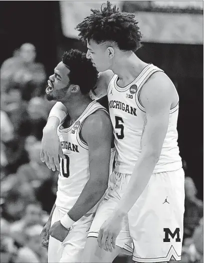  ?? ROBERSON/THE ASSOCIATED PRESS] [JEFF ?? Michigan’s D.J. Wilson hugs Derrick Walton Jr., who scored 26 points and had 11 assists in Michigan’s win. KANSAS 100, UC DAVIS 62: OREGON 93, IONA 77: MICHIGAN STATE 78, MIAMI 58: