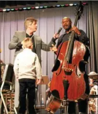  ?? CHRIS BARBER — DIGITAL FIRST MEDIA ?? Kennett Symphony Director Michael Hall directs questions about the bass to musician Douglas Mapps, holding the instrument, as a child who asked about it looks on.