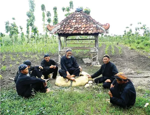  ??  ?? BERSEJARAH : Lasiyo duduk di atas batu yang konon jadi pusat persebaran Samin pada zaman dahulu. Hingga sekarang, batu itu digunakan untuk mengajarka­n nilai-nilai Samin kepada Sedulur Sikep.