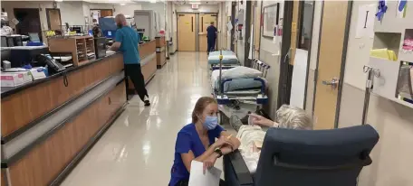  ?? Ap FiLe ?? NOT SO MANY: A nurse talks with a patient in the emergency room of Salem Hospital in Salem, Ore. Many hospitals are understaff­ed because nurses have retired or taken jobs as traveling nurses.