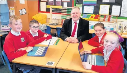  ??  ?? Oswaldtwis­tle Moor End primary school headteache­r Andy Martin pictured with year 5 pupils celebratin­g their latest ‘good’ Ofsted rating