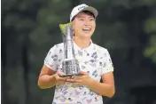  ?? TIM IRELAND/ASSOCIATED PRESS ?? Japan’s Hinako Shibuno smiles as she holds the trophy after winning the Women’s British Open at Woburn Gold Club in England on Sunday.