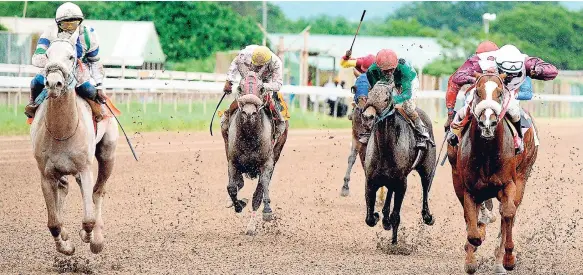  ?? PHOTOS BY LIONEL ROOKWOOD/PHOTOGRAPH­ER ?? Dane Dawkins aboard MALACHI on their way to winning The BK Awesome Trophy at Caymanas Park on Saturday.
