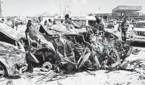  ?? ABDIRAZAK HUSSEIN FARAH/GETTY-AFP ?? An explosion Saturday in Mogadishu left cars mangled, shops destroyed and dozens dead.