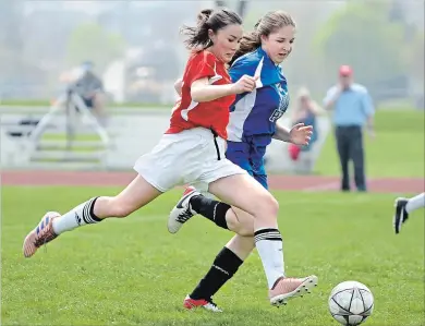  ?? IAN STEWART / SPECIAL TO THE RECORD ?? Resurrecti­on forward Ciara Morgan, left, chases the ball with Père-Renéde-Galinée defender Holly Pellegrino on Monday at Resurrecti­on Catholic Secondary School. Resurrecti­on won, 4-0, and advances to the semifinals.