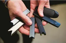  ?? CRAIG MITCHELLDY­ER/AP ?? In this April 16, 2019 photo, a researcher holds vape pens in a laboratory in Portland, Ore. On Thursday, Sept. 9, 2021, U.S. health officials delayed a high-stakes decision on whether to permit best-selling vaping brand Juul to stay on the market, while ordering thousands of other electronic cigarettes off store shelves.