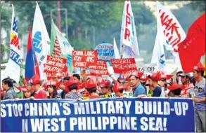  ?? TED ALJIBE /AFP ?? Activists carry placards during a protest in front of the Chinese consulate in Manila on February 10.