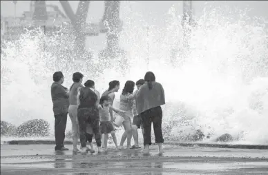  ?? VICTOR YANEZ / REUTERS ?? A family react to waves breaking over the sea wall ahead of Hurricane Franklin in Veracruz, Mexico, on Wednesday. The hurricane slammed into Mexico’s eastern coast on Thursday, sweeping the region with powerful winds and heavy rain.