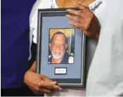  ?? STAFF FILE PHOTO BY ERIN O. SMITH ?? Linda Bonner holds onto a photo of her late husband, Franklin Bonner, during a news conference earlier this month. Linda Bonner returned home from work, Jan. 16, 2009, to find her home ransacked and her husband murdered, and the case was cold for nine years.