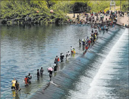  ?? Eric Gay The Associated Press file ?? Haitian migrants use a dam to cross into the United States from Mexico in September.