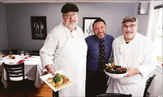 ?? Arnold Gold / Hearst Connecticu­t Media ?? Rosso Vino Wine Bar + Bistro owner Joe Flores, center, with chefs Joe Dusa, left, holding Capesante Picatta and Chris Rydell holding Cozze Fra Diavolo.