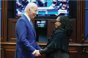  ?? The Associated Press ?? ■ President Joe Biden holds hands with Supreme Court nominee Judge Ketanji Brown Jackson as they watch the Senate vote on her confirmati­on Thursday from the Roosevelt Room of the White House in Washington.