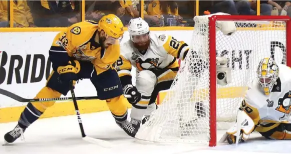  ?? FREDERICK BREEDON/GETTY IMAGES ?? Nashville’s Frederick Gaudreau outraces Pittsburgh’s Ian Cole and barely beats goalie Matt Murray with a wraparound that danced tantalizin­gly on the goal line in Game 4 on Monday night.