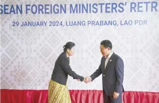  ?? TANG CHHIN SOTHY/AGENCE FRANCE-PRESSE ?? LAOS’ Foreign Minister Saleumxay Kommasith (right) shakes hands with Myanmar Permanent secretary Marlar Than Htike during the ASEAN Foreign Ministers’ retreat meeting in Luang Prabang.