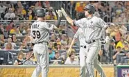  ?? JUSTIN BERL/GETTY IMAGES ?? Tyler Moore #28 of the Miami Marlins is greeted by JT Riddle #39 after hitting one of his two home runs on Friday night.