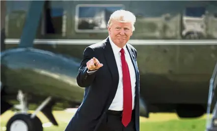  ??  ?? In the spotlight: Trump walking from Marine One to the White House in Washington, DC. — AFP