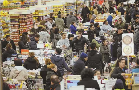  ?? STAFF PHOTO BY NICOLAUS CZARNECKI ?? FOOD RUN: Shoppers stock up at the Market Basket in Chelsea yesterday before the coming storm.