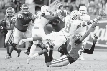  ?? Luis Sinco Los Angeles Times ?? OREGON SAFETY Jevon Holland gets a hand on the ball but is called for pass interferen­ce as he defends USC wide receiver Drake London in the first quarter. Oregon fell behind early but went on to win the game 56-24.